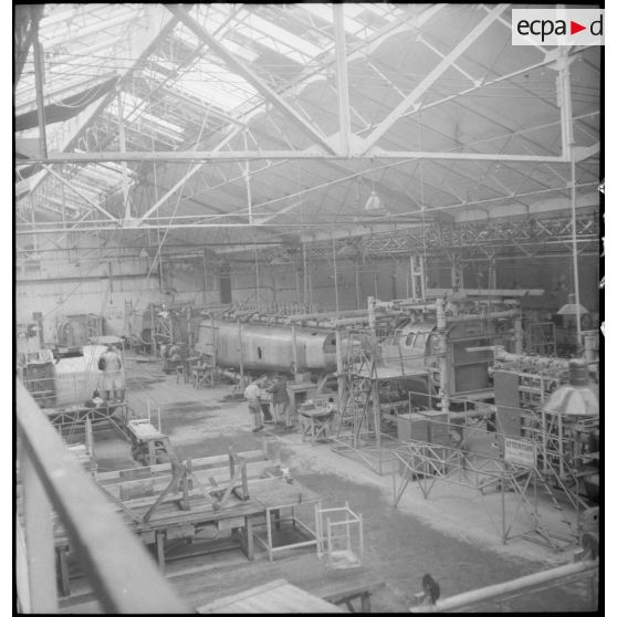 Vue d'ensemble sur les éléments d'un avion 'Heinkle He-274 dans le hall d'une usine française.
