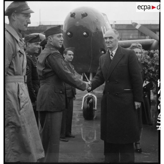 Tillon sert la main à un caporal chef américain lors de la cérémonie officielle du baptême de l'avion "France Libre" le 25 octobre 1944, au Bourget.