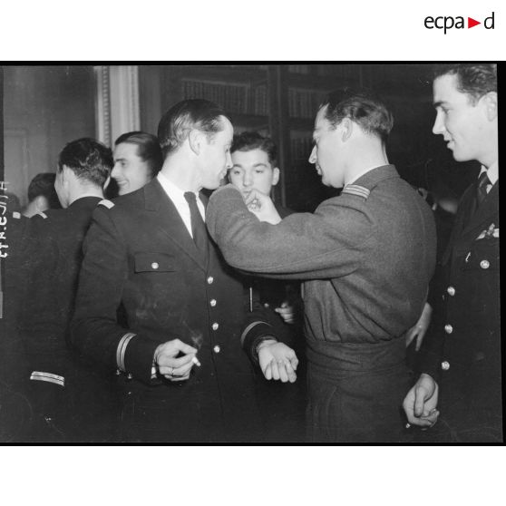 Le commandant du groupe de chasse Alsace attache la fourragère à l'un des pilotes.