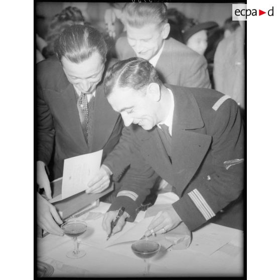 Pierre Pouyade signe des autographes lors de la réception des pilotes du groupe de chasse Normandie-Niemen organisée par la FNSA.