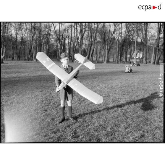 Enfant portant une maquette d'avion à Vincennes.