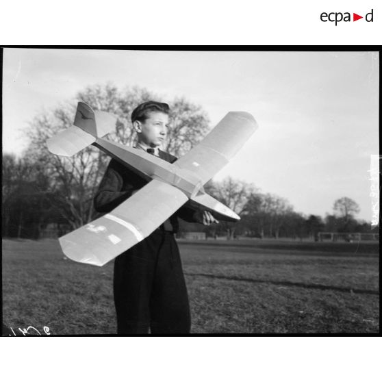 Enfant portant une maquette d'avion à Vincennes.