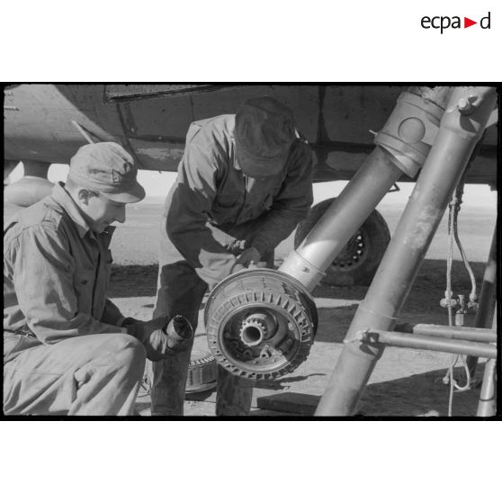 Mécaniciens réparant un train d'atterrissage d'un B-26 Marauder sur la piste en Sardaigne.
