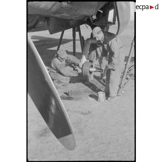 Mécaniciens réparant un train d'atterrissage d'un B-26 Marauder sur la piste en Sardaigne.