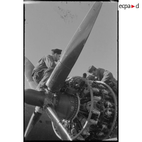 Mécanicien au travail sur un des moteurs d'un bombardier sur la piste en Sardaigne.