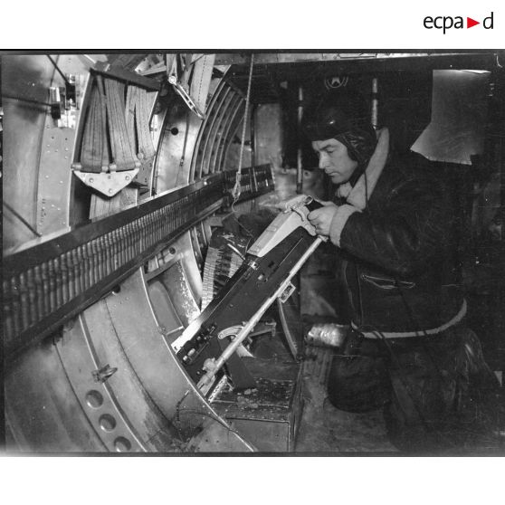 Mitrailleur de sabord d'un bombardier vérifiant sa ligne de mire.