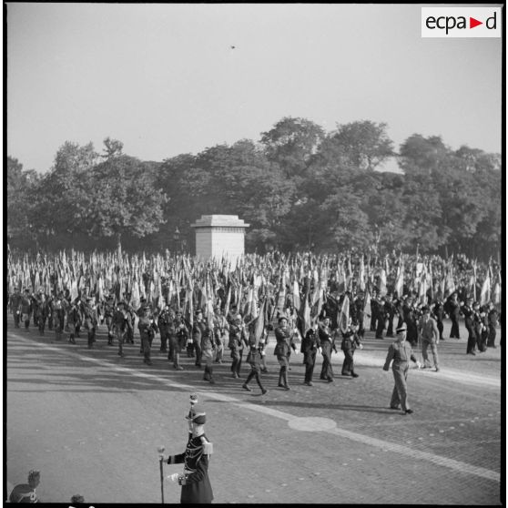 Défilé sur la place de la Concorde des porte-drapeaux et étendards des unités ayant pris part aux combats.
