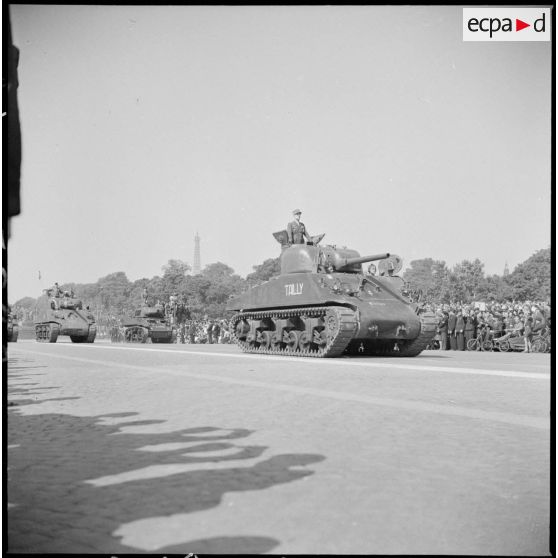 En tête du défilé de la Victoire, le général de corps d'armée Philippe Leclerc de Hauteclocque, commandant la 2e division blindée (2e DB), est à bord du char Sherman M4 baptisé Tailly.