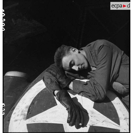 Un soldat, probablement le caméraman Gilles Auzias de Turenne, du service cinématographique de l'Armée (SCA), se repose sur le capot de son véhicule.