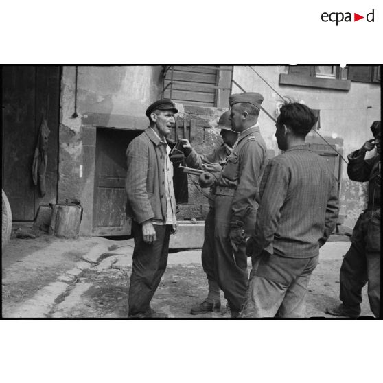 Un civil allemand est fouillé et interrogé par un commandant du 2e bataillon de zouaves portés (2e BZ).