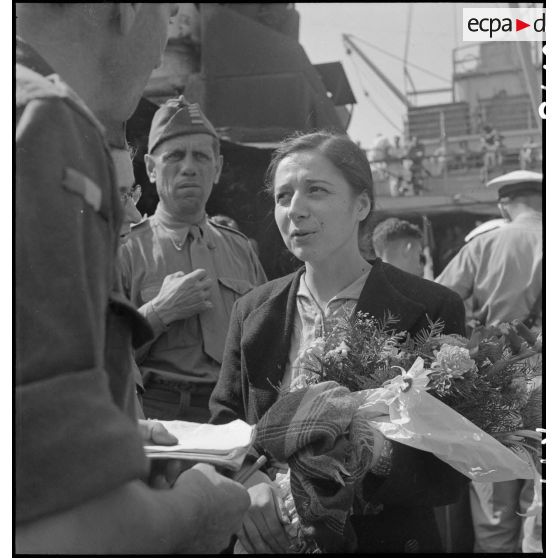 Une femme, rapatriée depuis Odessa d'un camp libéré par l'armée soviétique, après sa descente du paquebot transport de troupes Ascanius, est accueilie sur un quai à Marseille.