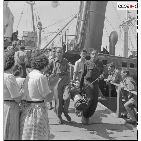 Un prisonnier de guerre blessé, rapatrié depuis Odessa d'un camp libéré par l'armée soviétique, est débarqué du paquebot transport de troupes Ascanius sur un quai à Marseille.
