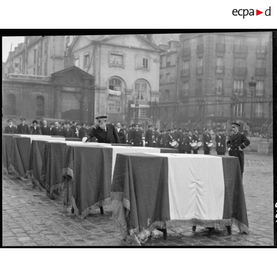 Remise de la croix de chevalier de la Légion d'Honneur par le commandant Cressaty sur les cercueils des défunts.