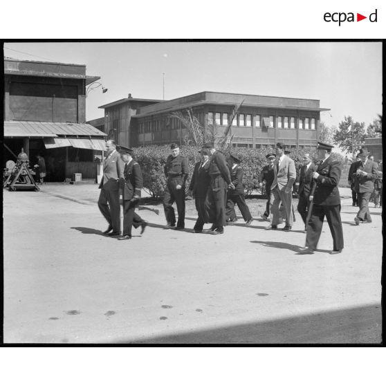 Fernand Grenier, commissaire à l'Air, accompagné des autorités militaires, se dirige vers les installations de l'atelier industriel de l'Air (AIA).