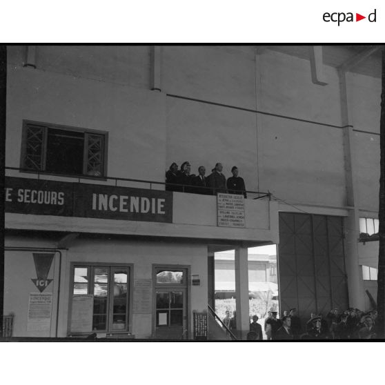 Fernand Grenier, commissaire à l'Air, et les autorités militaires pendant l'éxécution de la Marseillaise dans un hangar de l'atelier industriel de l'Air (AIA) de Maison Blanche.