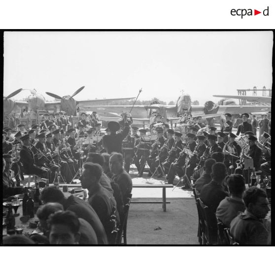 La musique de l'Air exécute les hymnes nationaux alliés lors de la visite de Fernand Grenier, commissaire à l'Air, à l'atelier industriel de l'Air de Maison Blanche.