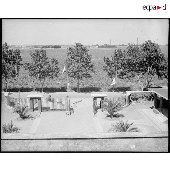 Les trois pavillons flottent à l'entrée de l'Atelier Industriel de l'Air de Maison Blanche, anglais, français et américain.