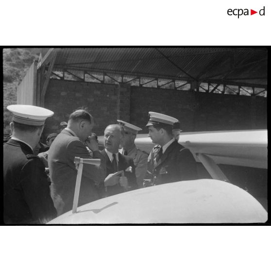 Lors de sa  visite du centre de vol à voile (sans moteur) du djebel Diss en compagnie du colonel de Brion, Fernand Grenier, commissaire à l'Air, s'entretient avec des personnels.