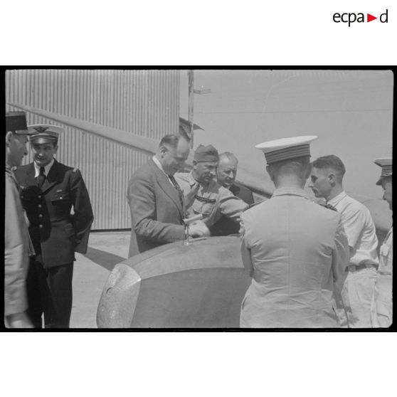 Le lieutenant Ferrarris, moniteur en chef du centre de vol à voile (sans moteur) du djebel Diss, donne des explications à Fernand Grenier, commissaire à l'Air, lors de sa visite.