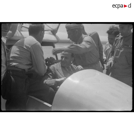 Lors de sa  visite du centre de vol à voile (sans moteur) du djebel Diss, Fernand Grenier, commissaire à l'Air, monte dans un planeur.