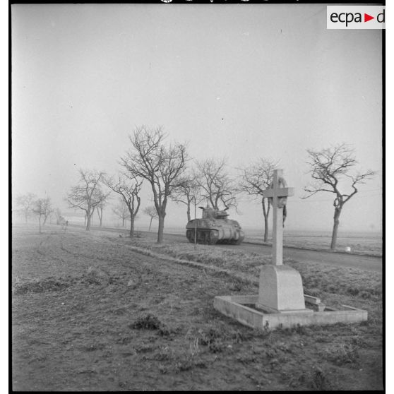 Un char Sherman du 4e escadron du 2e RC (Régiment de cuirassiers) progresse sur une route au nord-est de Mulhouse (Haut-Rhin) pour mener une contre-attaque. [description provisoire]