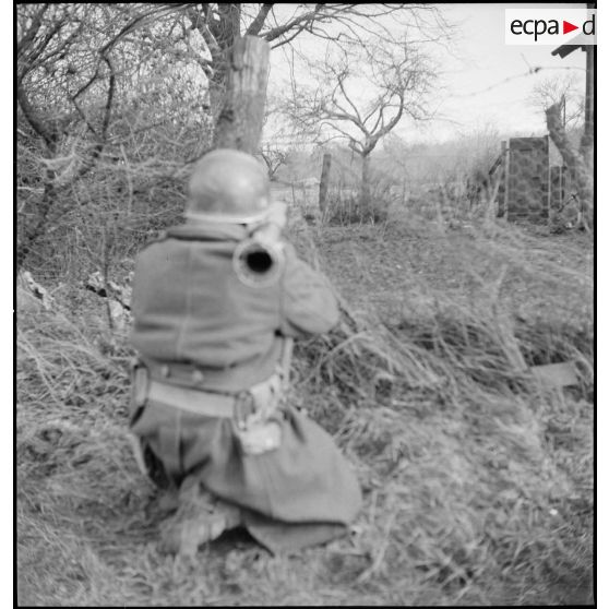 Début décembre 1944, un fantassin de la 4e DMM (Division marocaine de montagne) armé d'un bazooka, avance avec son unité appuyée par les chars de la 1re DB (Division blindée), pour mener une contre-attaque dans la forêt de la Hardt (Harth) au nord-est de Mulhouse (Haut-Rhin). [description provisoire]