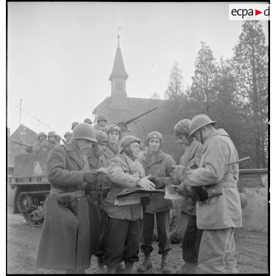 Le capitaine Camille Doré de la 1re DB (Division blindée) donne ses instructions relatives à une attaque à mener au nord-est de Mulhouse (Haut-Rhin) aux officiers de son unité à son poste de commandement volant. [description provisoire]