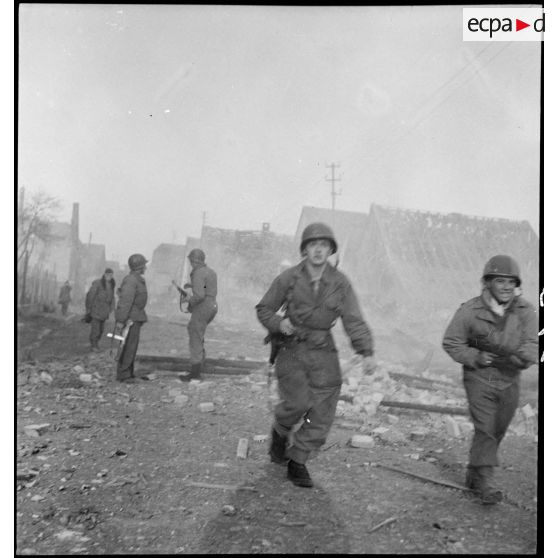 Rhinau (Bas-Rhin) est en proie aux flammes et en ruine, le village alsacien ayant été bombardé par les Allemands entre le 10 et le 22 décembre 1944. Les troupes patrouillent dans la commune dévastée. [description provisoire]