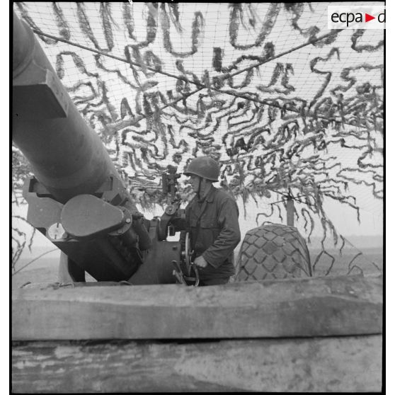 Artilleur du 1er groupe du 3e RAC (Régiment d'artillerie coloniale) servant un canon de 155 mm Gun implanté près de Limersheim (Bas-Rhin) : pointeur, il effectue les réglages pour l'exécution du tir sur les positions allemandes. [description provisoire]