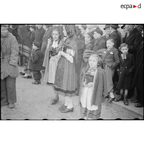 Habitants en costume traditionnel alsacien devant les libérateurs. [description provisoire]