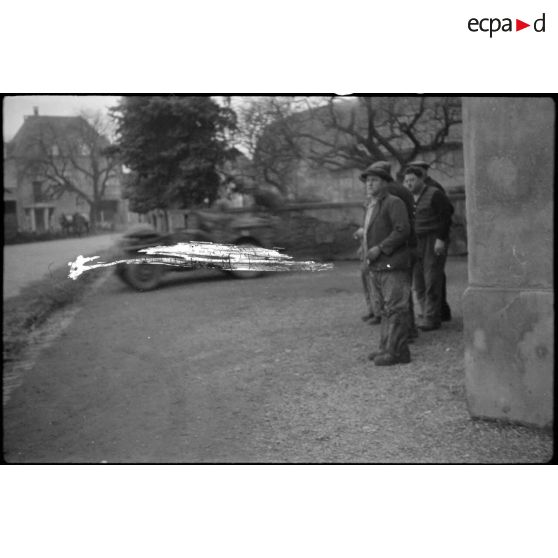 Des civils observent le déplacement en patrouille d'éléments du RICM (Régiment d'infanterie coloniale du Maroc) en direction de Rosenau (Haut-Rhin). [description provisoire]