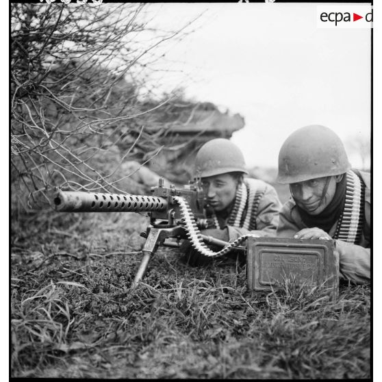 Deux soldats tirent à la mitrailleuse Browning lors d'un exercice avec des chars Sherman du 1er RCA (Régiment de chars d'Afrique), de la 5e DB (Division blindée), dans la région de Colmar (Haut-Rhin). [description provisoire]