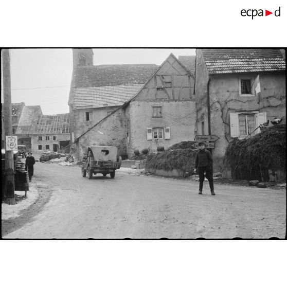Une jeep de la 2e DB (Division blindée) traverse le village de Weyer (Bas-Rhin), PC (poste de commandement) de la 2e DB. [description provisoire]
