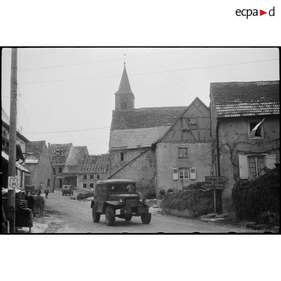 Un command car  de la 2e DB (Division blindée) traverse le village de Weyer (Bas-Rhin), PC (poste de commandement) de la 2e DB. [description provisoire]