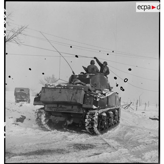 Patrouille de chars Sherman du 12e RCA, en appui de fantassins du RMT, dans le secteur enneigé de Gros-Réderching (Moselle). [description provisoire]