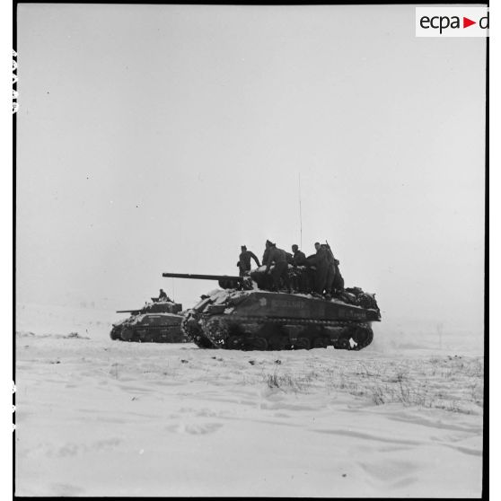 Patrouille de chars Sherman du 12e RCA, en appui de fantassins du RMT, dans le secteur enneigé de Gros-Réderching (Moselle). [description provisoire]