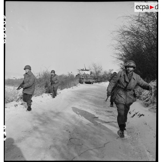 Patrouille de reconnaissance et opération de nettoyage dans un village du front dans le secteur de Gros-Réderching (Moselle), par une unité de chars du 12e RCA, accompagnée d'éclaireurs de l'infanterie du RMT. [description provisoire]