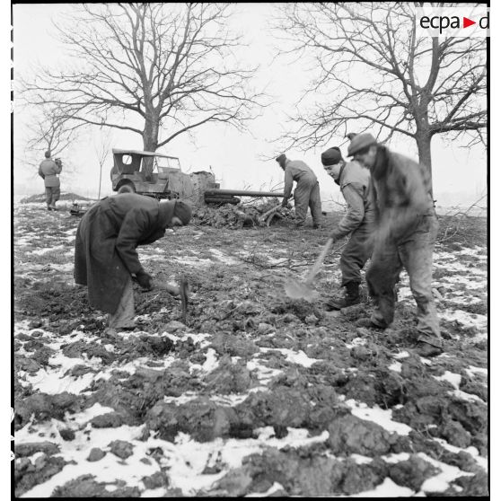 Des canonniers d'une section du 21e groupe antillais des FTA (Forces terrestres antiaériennes), qui fait partie de la 1re DMI (Division de marche d'infanterie) (ex 1re DFL), mettent en batterie une pièce de DCA et préparent une position de défense aux portes d'Obernai (Bas-Rhin) pour assurer la protection de la ville. [description provisoire]