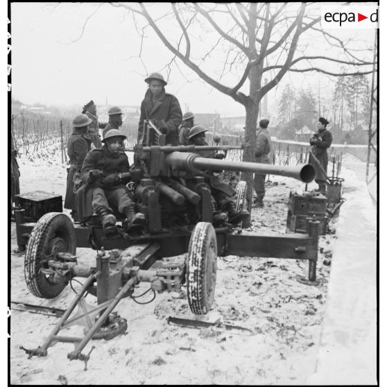 Des canonniers d'une section du 21e groupe antillais des FTA (Forces terrestres antiaériennes), qui fait partie de la 1re DMI (Division de marche d'infanterie) (ex 1re DFL), mettent en batterie une pièce de DCA (un canon Bofors de 40 mm) aux portes d'Obernai (Bas-Rhin) dont ils doivent assurer la défense. [description provisoire]