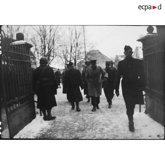 Délégation d'attachés militaires étrangers en visite sur le front d'Alsace, traversant le village de Steinbrunn-le-Bas (Haut-Rhin) où se trouve le PC de la 9e DIC (Division d'infanterie coloniale). [description provisoire]