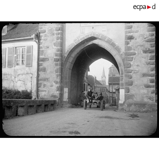 Elèves se rendant en charrette à l'école dans le village de Boersch (Bas-Rhin) en passant par la Tour-Basse. [description provisoire]