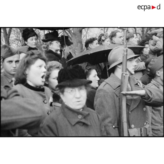 Foule venue assister à la cérémonie célébrant la libération de la ville de Colmar, chantant la Marseillaise. [description provisoire]