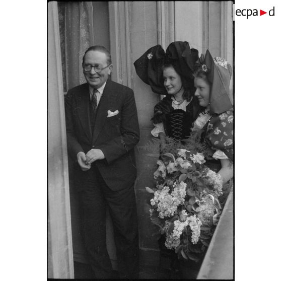 Le ministre à la Guerre, André Diethelm, reçoit deux jeunes femmes revêtues du costume traditionnel alsacien, à Paris. [description provisoire]