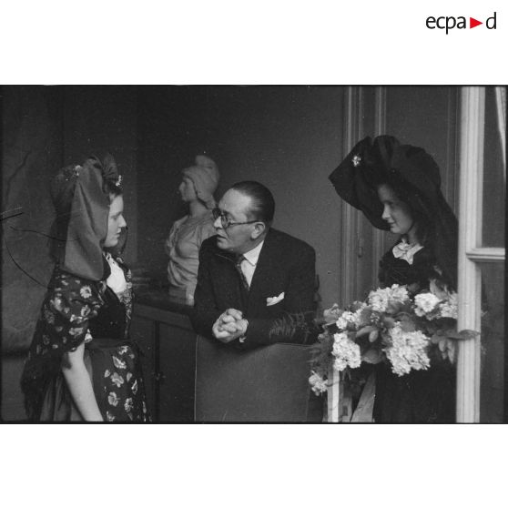 Le ministre à la Guerre, André Diethelm, reçoit deux jeunes femmes revêtues du costume traditionnel alsacien, à Paris. [description provisoire]