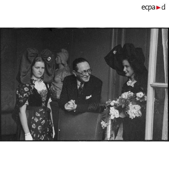 Le ministre à la Guerre, André Diethelm, reçoit deux jeunes femmes revêtues du costume traditionnel alsacien, à Paris. [description provisoire]