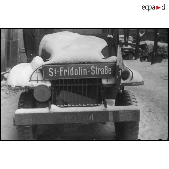 Plaque de rue allemande installée sur la calandre d'un camion GMC de la 297e compagnie du Train de la 2e division blindée (2e DB).