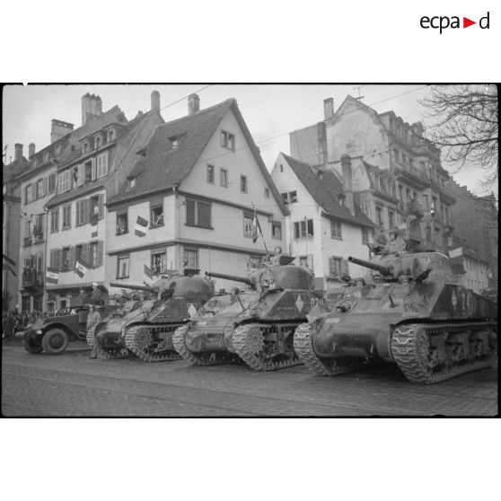 Des chars Sherman M4A2 de l'escadron d'état-major du 6e régiment de chasseurs d'Afrique (6e RCA) sont alignés pour la revue des troupes par le général de Gaulle.
