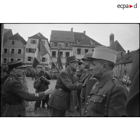 Lors de sa visite à Saverne, au cours d'une cérémonie, le général de Gaulle remet les insignes de grand-officier de la Légion d'honneur et la croix de Guerre au lieutenant général américain Jacob Devers, commandant le 6e groupe d'armées,