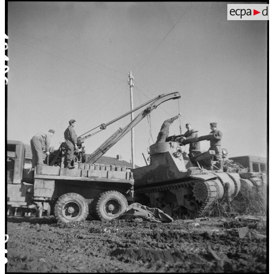 Pose d'un canon de 105 mm sur le berceau d'un canon automoteur M7 par une dépanneuse du groupe d'escadrons de réparation (GER XV) de la 2e division blindée (2e DB).