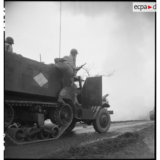 Un caméraman du SCA quittant un half-track, une caméra Bell & Howell à la main. [description provisoire]